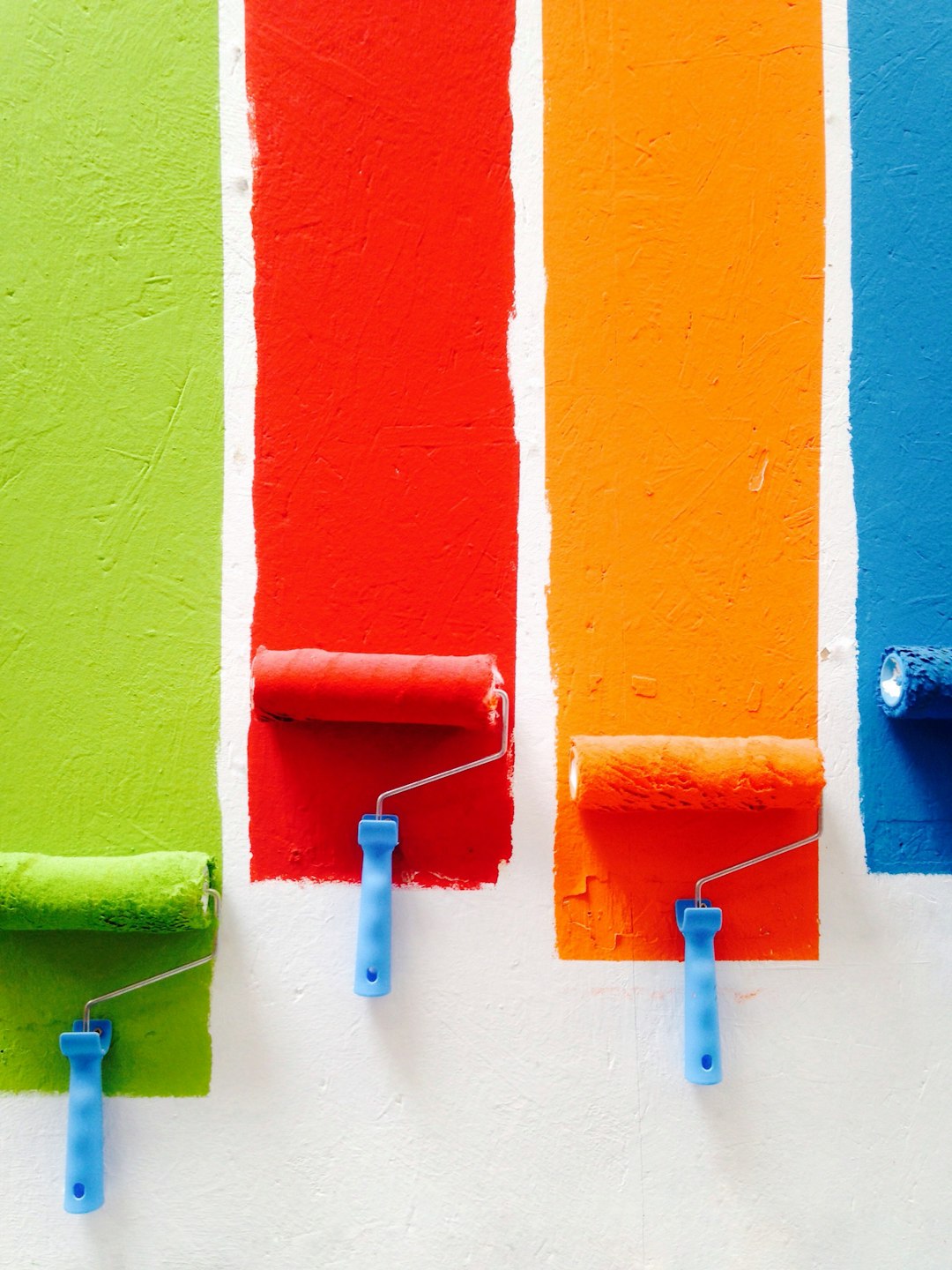 four-orange-green-blue-and-red-paint-rollers-46jud4zy1xa